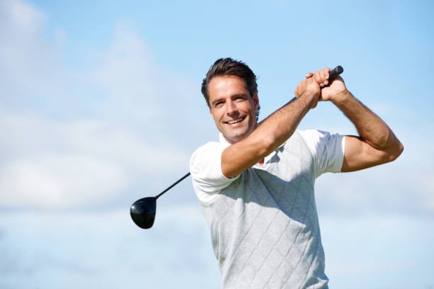 Positive mature golfer swinging his golf club out on the course