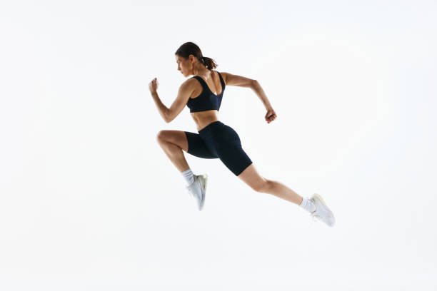Dynamic image of young woman with strong, healthy, sportive body in sportswear in motion, training isolated over white studio background. Concept of sport, health and body care, fitness app