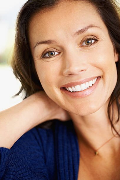 Closeup portrait of a cheerful middle aged woman giving you a cute smile